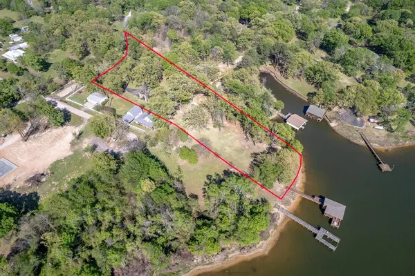 an aerial view of a house with a yard and lake view