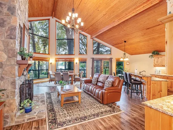 a living room with furniture large windows and wooden floor