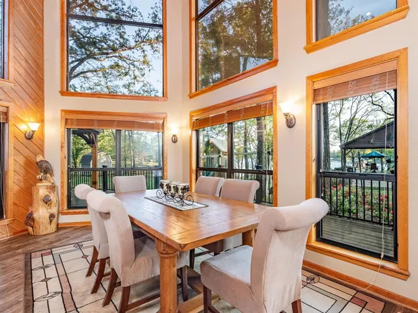 a view of a dining room with furniture large windows and wooden floor