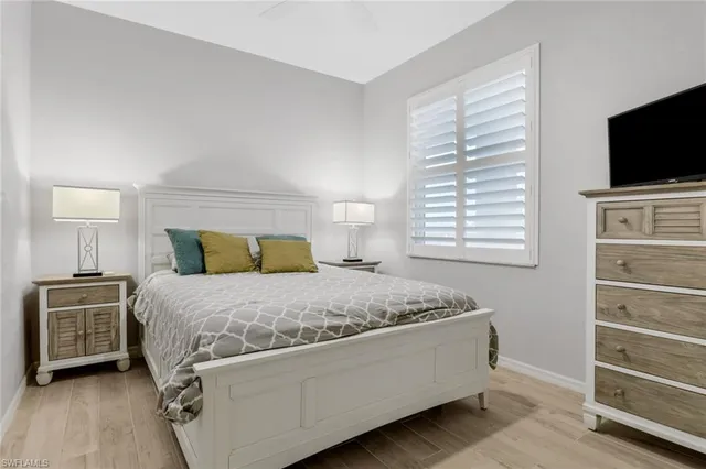 a bedroom with a bed and flat tv screen on a dresser