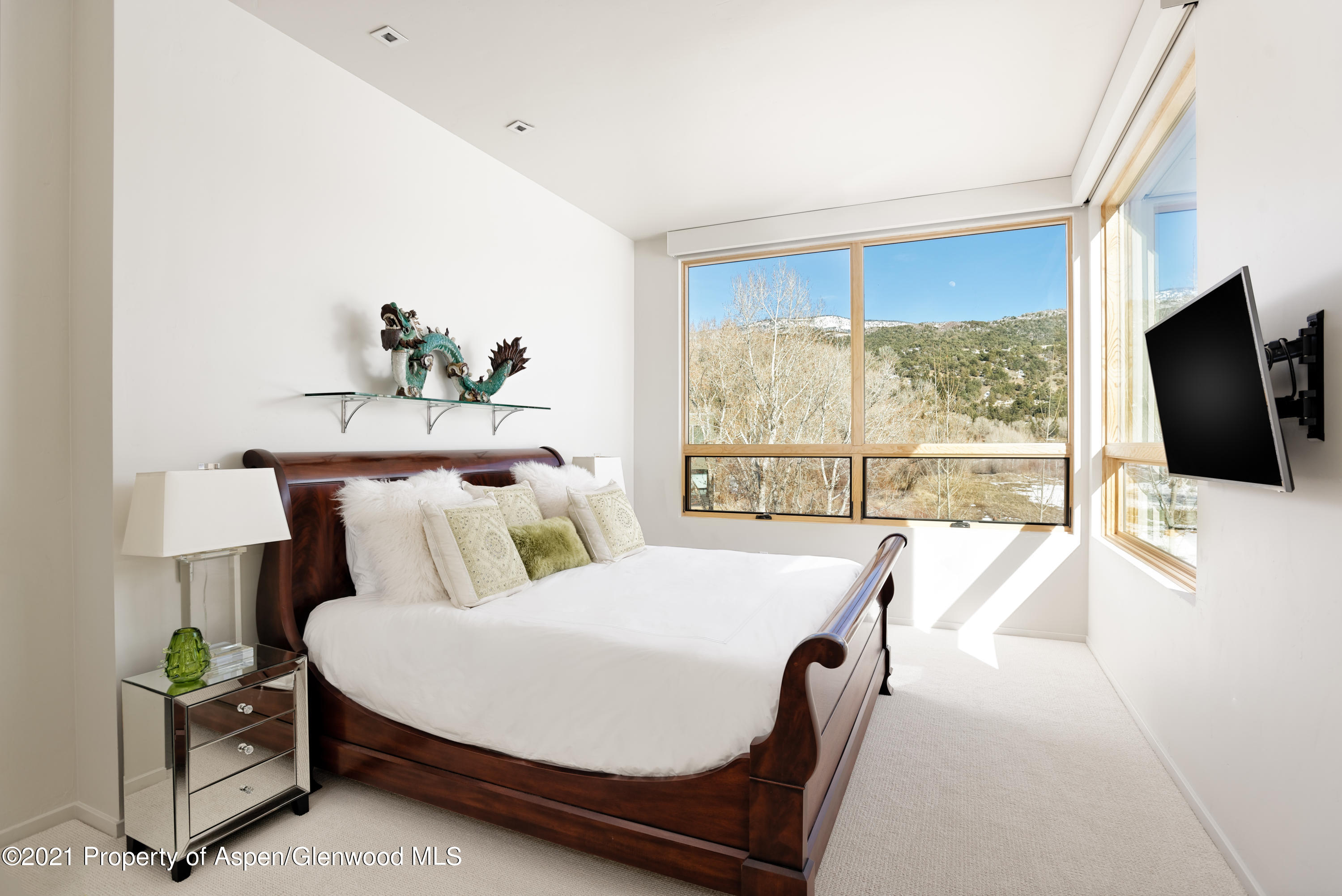 104 Evans Road, Unit 205 Basalt, CO 81621 - Photo 10 of 16 a bedroom with a large bed and a flat tv screen on dresser