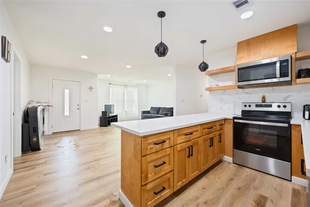 a kitchen with stainless steel appliances granite countertop a stove a sink and a refrigerator