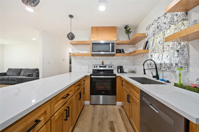 a kitchen with sink a stove and cabinets