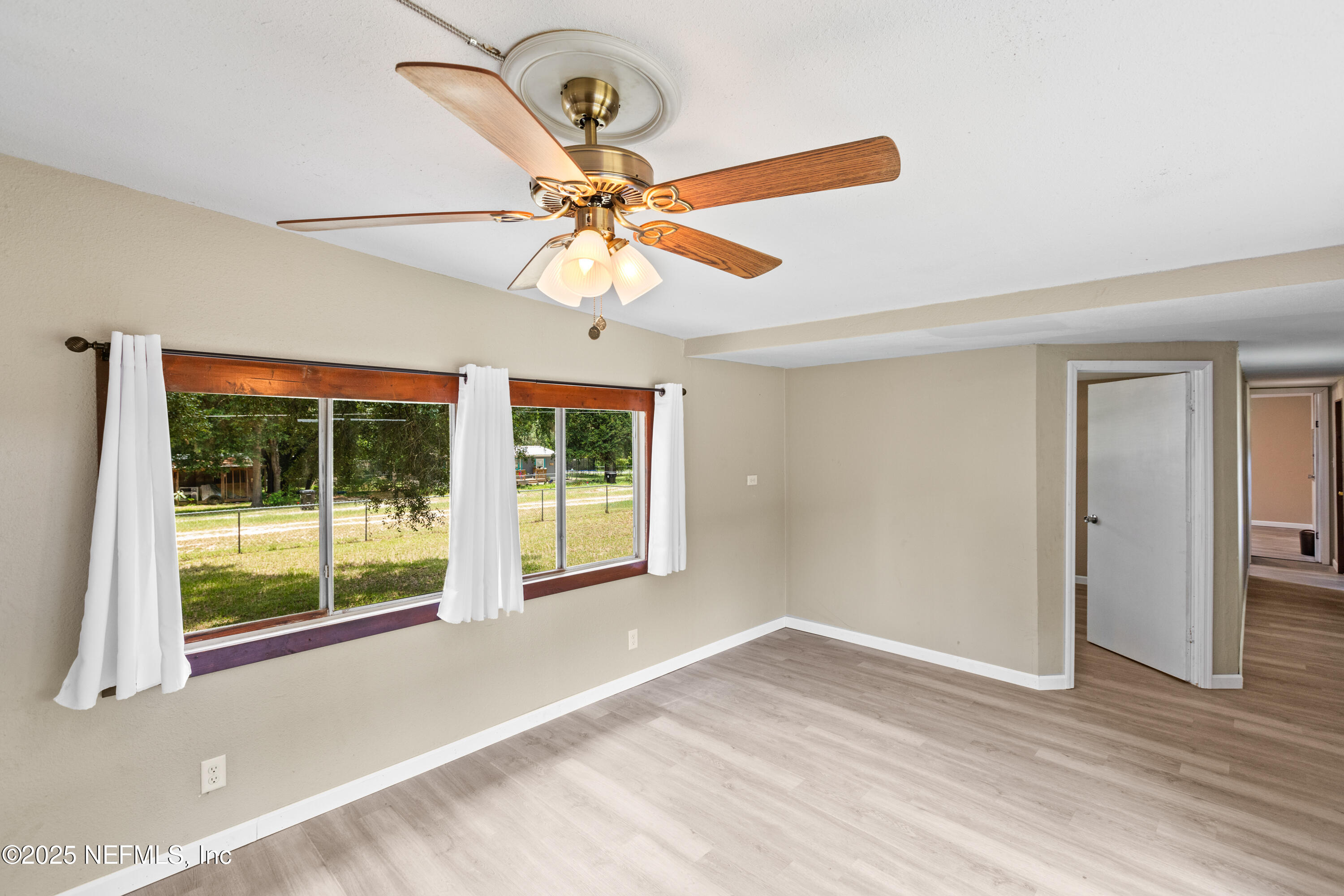 6398 Cascade Drive Keystone Heights, FL 32656 - Photo 20 of 31 a view of an empty room with window and chandelier fan