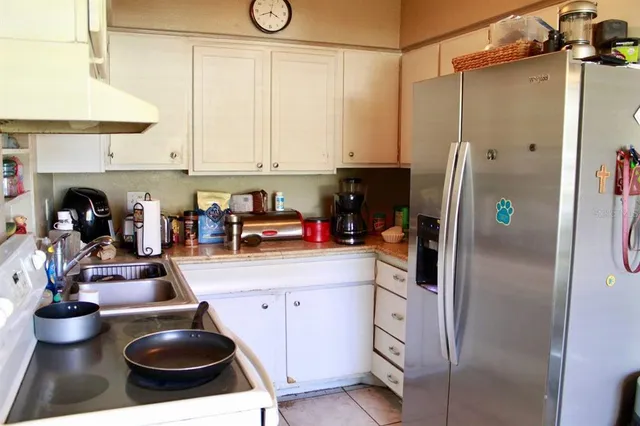 a kitchen with stainless steel appliances granite countertop a sink a stove and a refrigerator