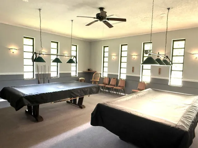 a living room with stainless steel appliances kitchen island granite countertop furniture and a chandelier