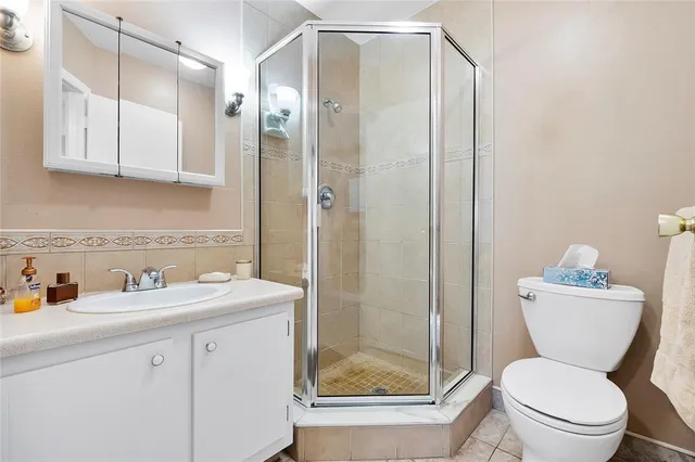 a bathroom with a toilet sink vanity and shower
