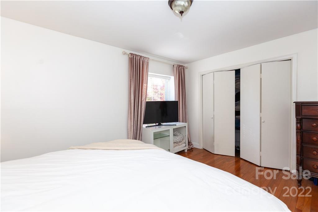 2600 Park Road, Unit C Charlotte, NC 28209 - Photo 13 of 20 a bedroom with a bed and a flat tv screen on wall