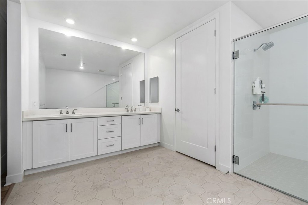 1202 Rivington Irvine, CA 92612 - Photo 14 of 52 a spacious bathroom with a double vanity sink a large mirror and shower