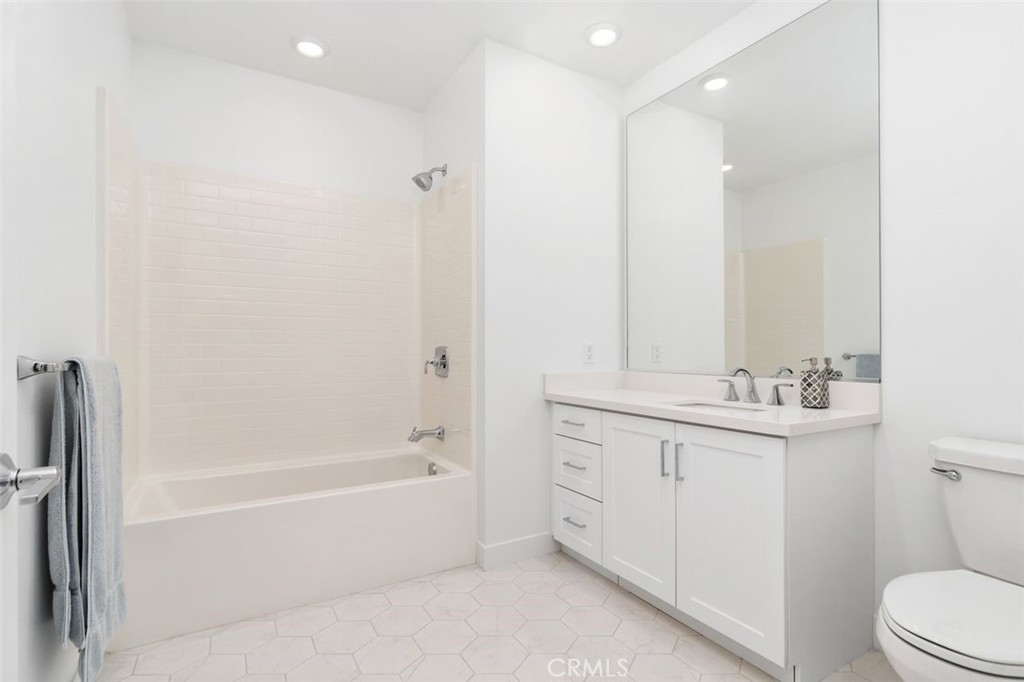 1202 Rivington Irvine, CA 92612 - Photo 18 of 52 a bathroom with a bathtub a sink a toilet and a mirror