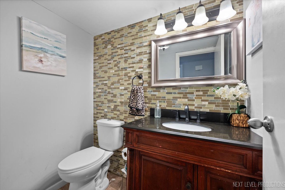 1094 Cascade Drive Aurora, IL 60506 - Photo 11 of 21 a bathroom with a granite countertop toilet sink and mirror