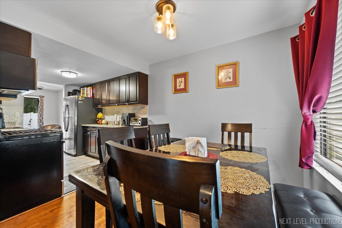 1094 Cascade Drive Aurora, IL 60506 - Photo 3 of 21 a view of a dining room with furniture a chandelier and wooden floor
