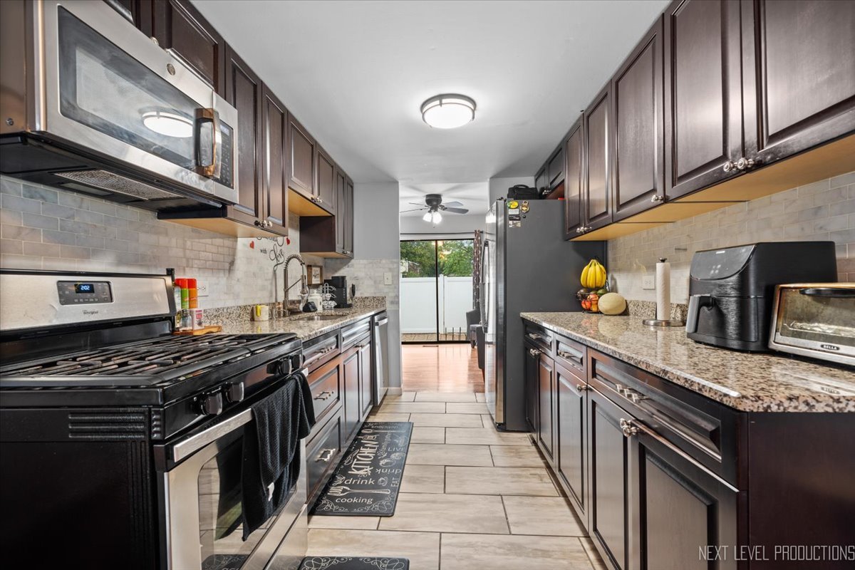 1094 Cascade Drive Aurora, IL 60506 - Photo 4 of 21 a kitchen with stainless steel appliances granite countertop a stove a sink dishwasher and a refrigerator