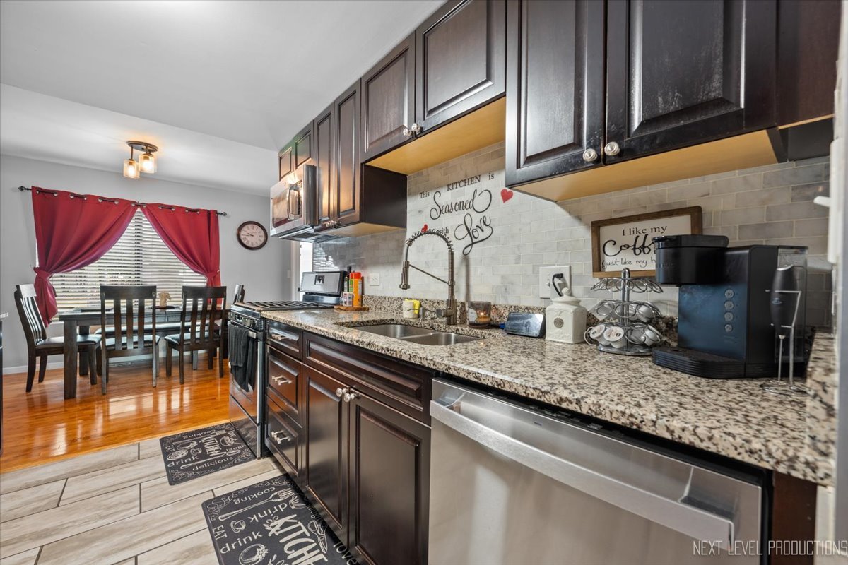 1094 Cascade Drive Aurora, IL 60506 - Photo 5 of 21 a kitchen with stainless steel appliances granite countertop a sink and cabinets