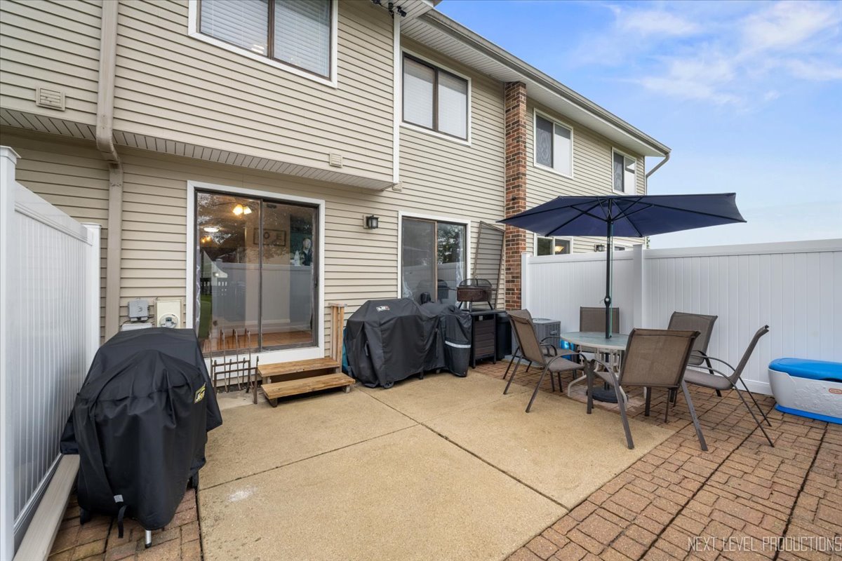 1094 Cascade Drive Aurora, IL 60506 - Photo 9 of 21 a view of a patio with table and chairs under an umbrella