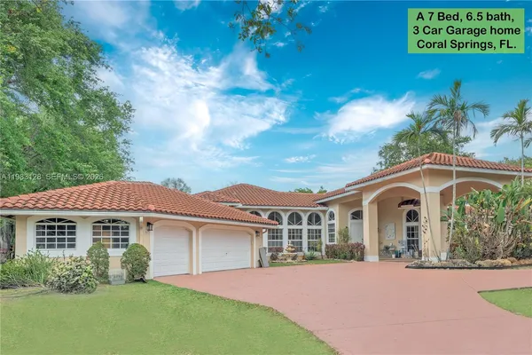 a room with stainless steel appliances lots of white furniture a window and a kitchen island