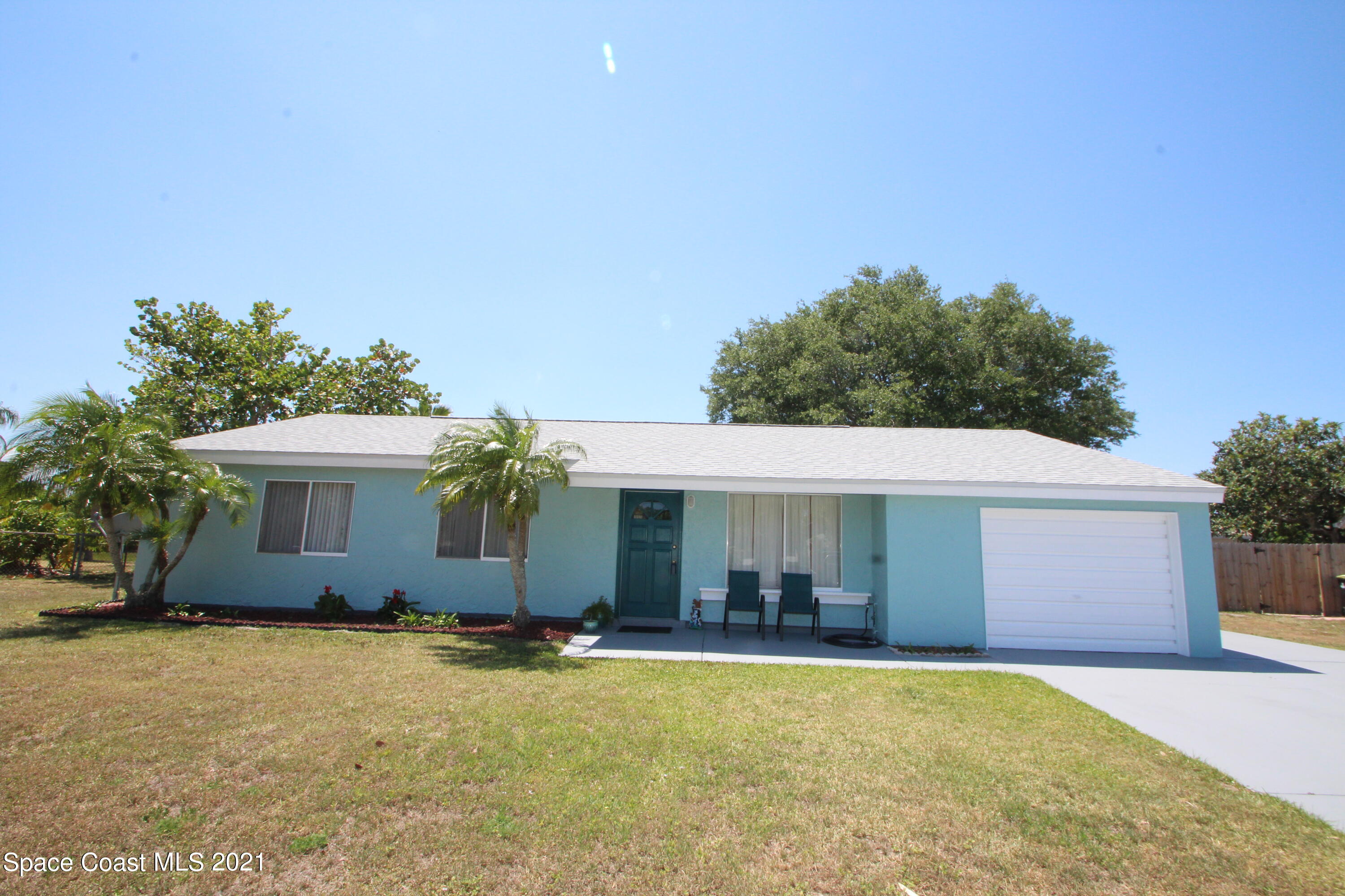 1398 Creel Road Northeast Palm Bay, FL 32905 - Photo 1 of 37 a front view of house with yard and trees in the background