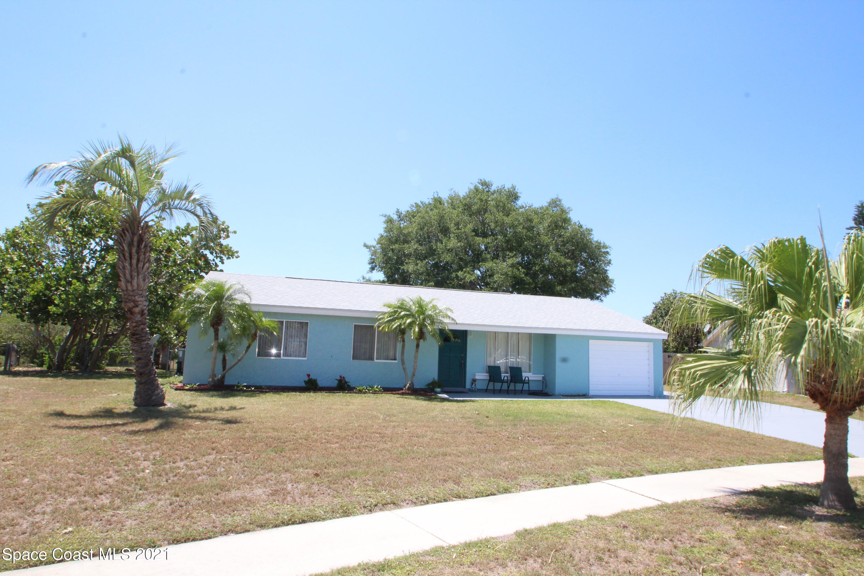 1398 Creel Road Northeast Palm Bay, FL 32905 - Photo 2 of 37 a front view of a house with a yard and a garage