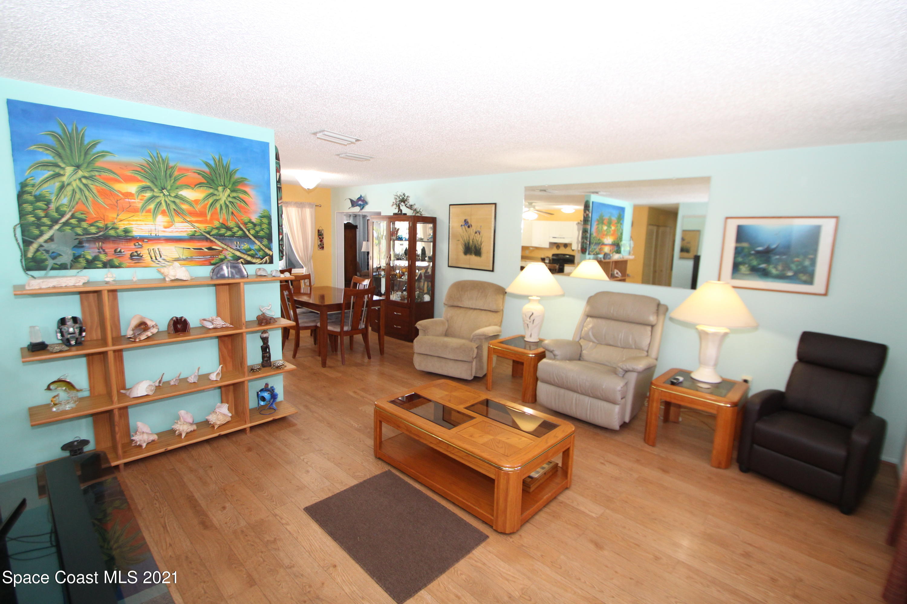 1398 Creel Road Northeast Palm Bay, FL 32905 - Photo 11 of 37 a living room with furniture a flat screen tv and a floor to ceiling window