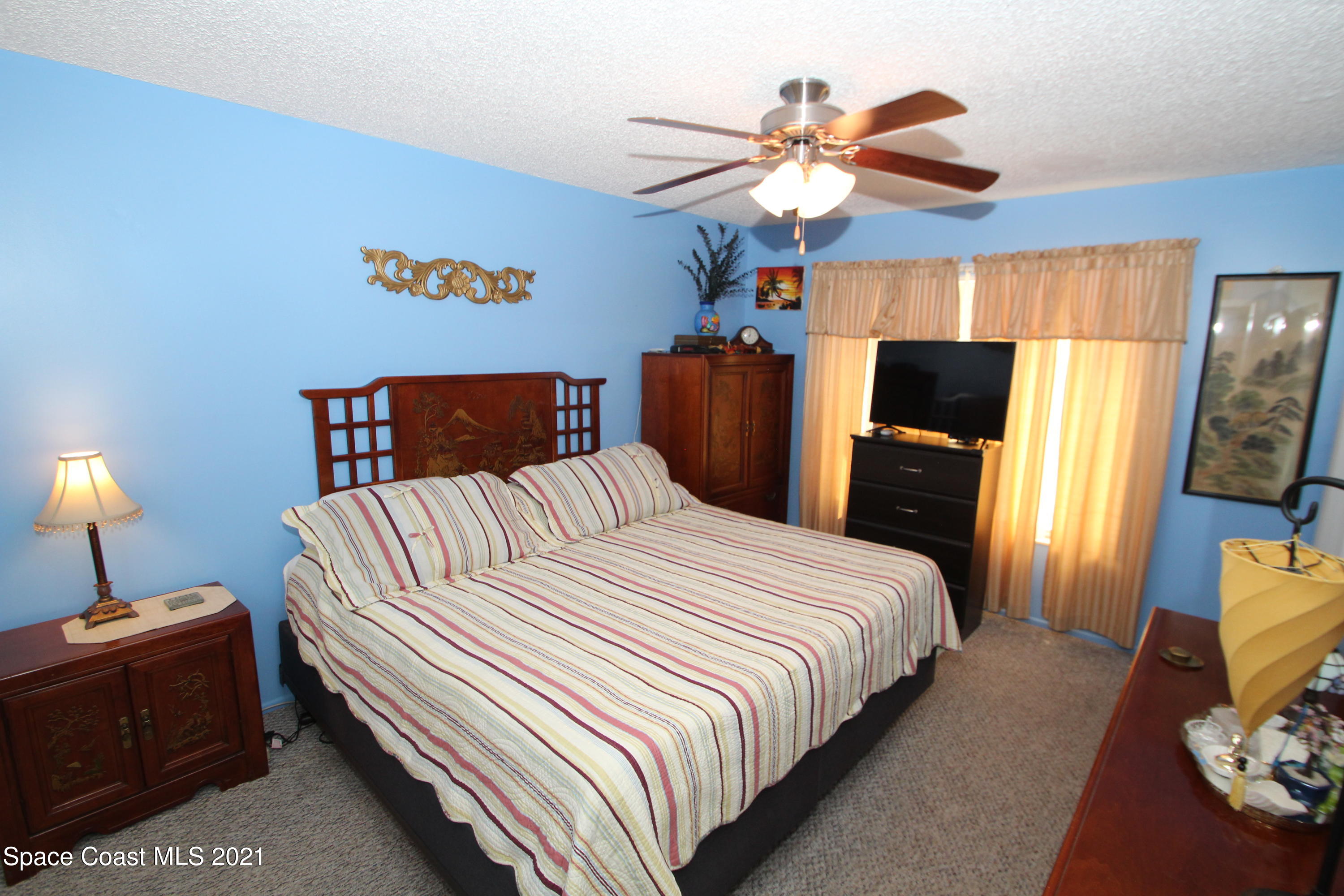 1398 Creel Road Northeast Palm Bay, FL 32905 - Photo 16 of 37 a bedroom with a bed and a chandelier