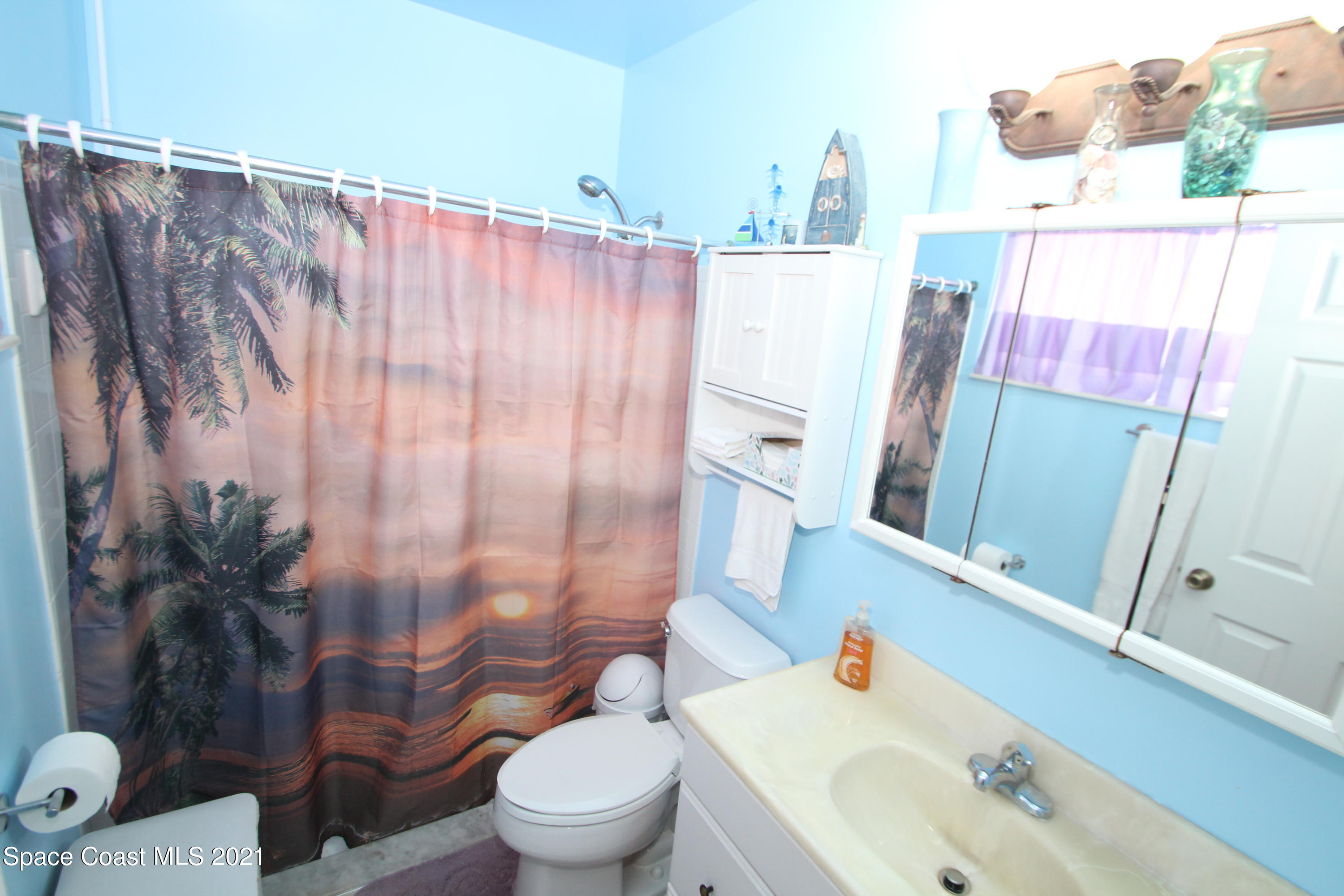 1398 Creel Road Northeast Palm Bay, FL 32905 - Photo 17 of 37 a white toilet sitting next to a bathroom sink