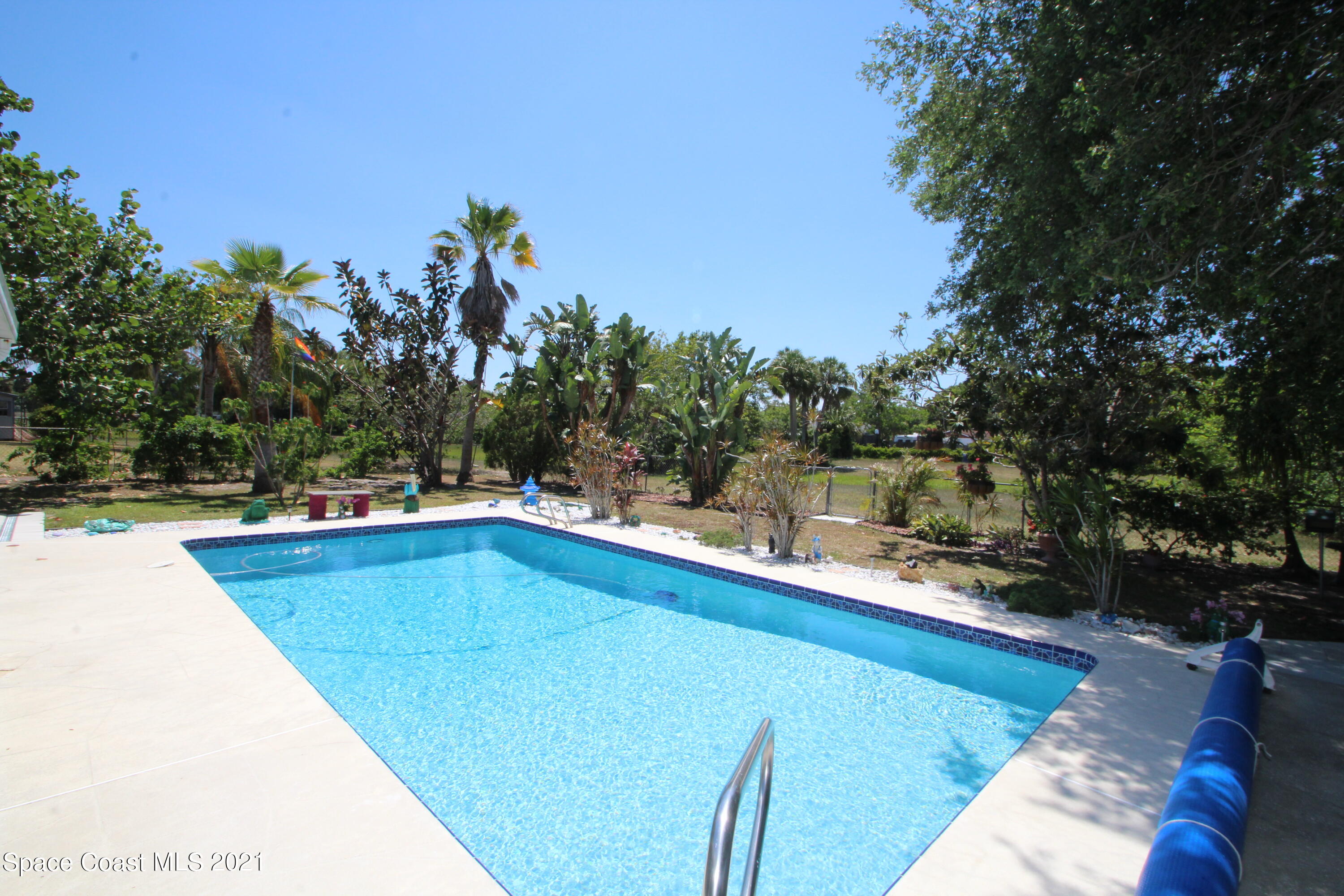1398 Creel Road Northeast Palm Bay, FL 32905 - Photo 24 of 37 a view of a swimming pool with a patio and a lake view