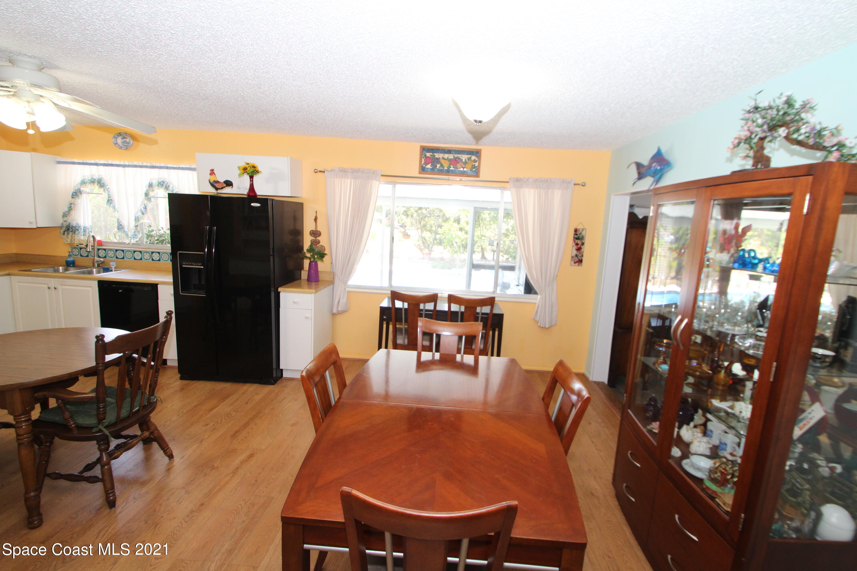 1398 Creel Road Northeast Palm Bay, FL 32905 - Photo 8 of 37 a dining room with furniture a chandelier and wooden floor