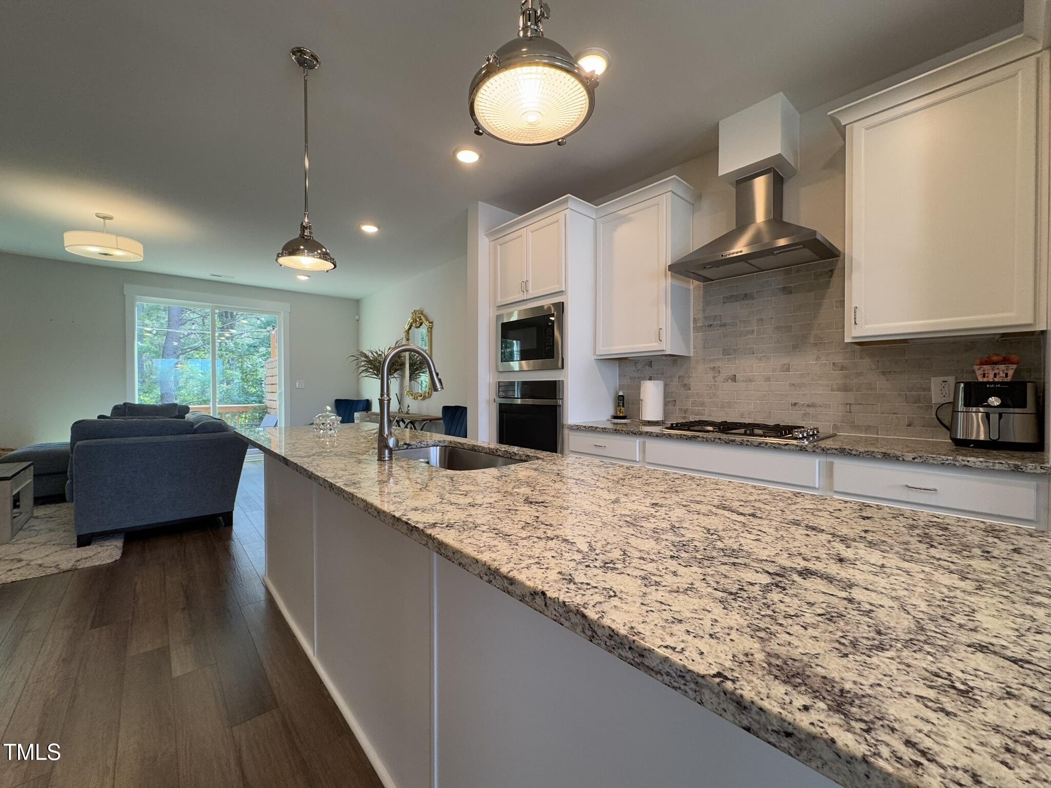 1244 Corkery Ridge Court Cary, NC 27519 - Photo 5 of 37 a large kitchen with kitchen island granite countertop a sink a counter space and stainless steel appliances