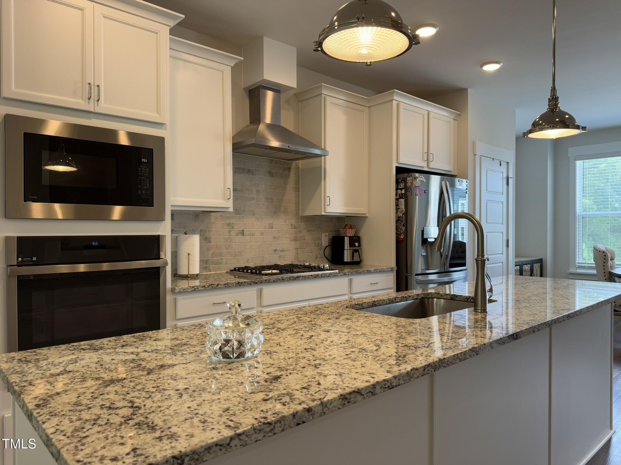 1244 Corkery Ridge Court Cary, NC 27519 - Photo 8 of 37 a kitchen with kitchen island granite countertop a sink appliances and cabinets