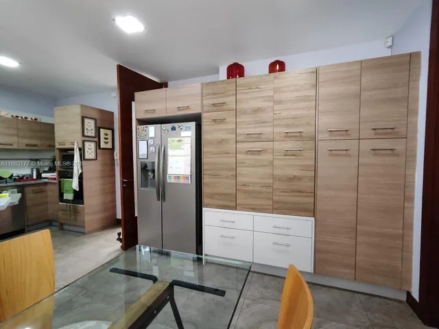 a room with lots of white furniture and chandelier
