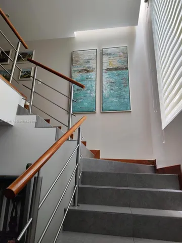 a bedroom with a bed lamp and a large window