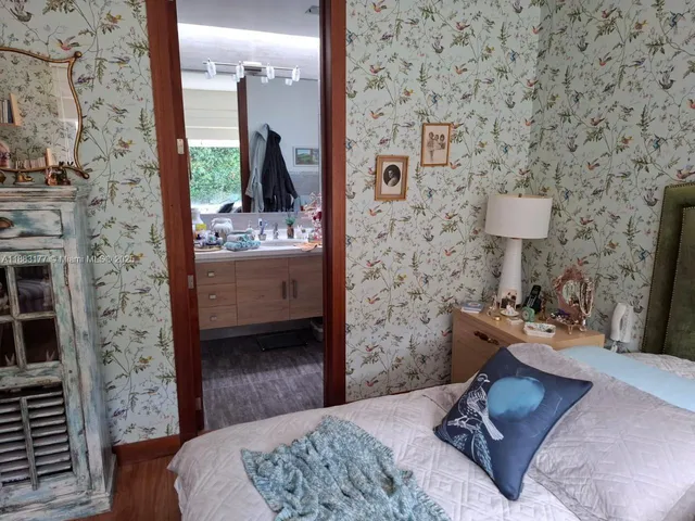 a bedroom with a bed and a lamp on dresser