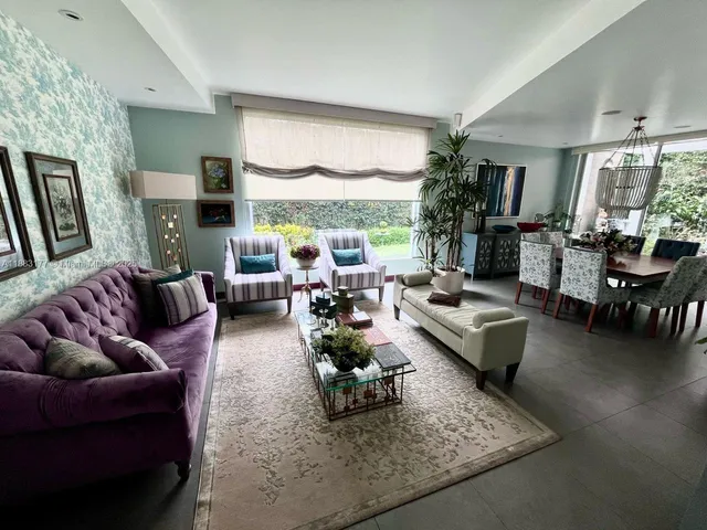 a living room with furniture large window and a table