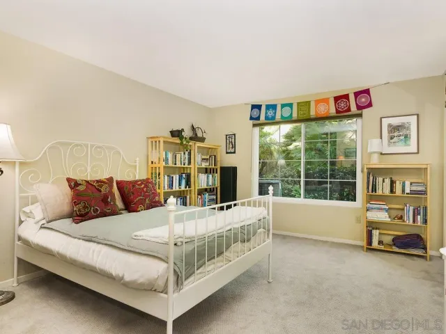 a bedroom with a bed and large window