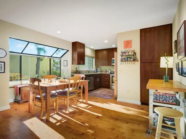 a view of a dining room with furniture a rug and wooden floor