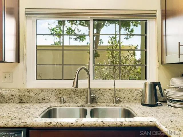 a kitchen sink with a granite countertop window