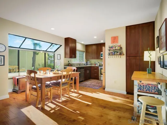 a view of a dining room with furniture a rug and wooden floor
