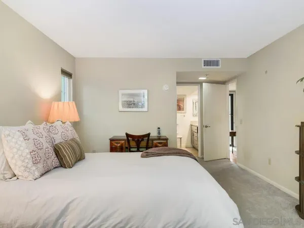 a bedroom with a bed and a lamp