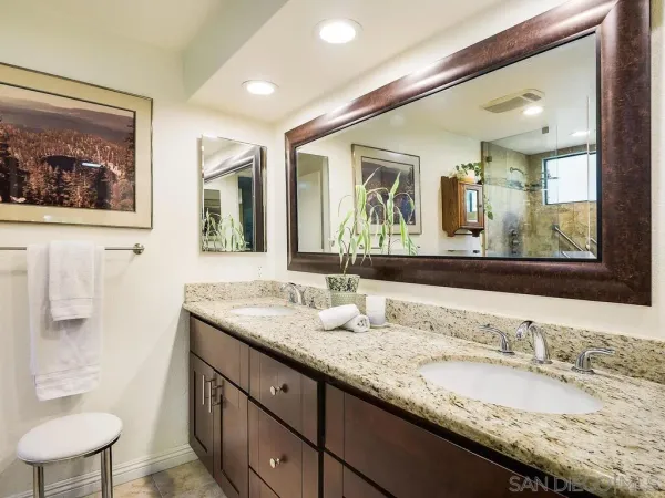 a bathroom with a granite countertop sink mirror and toilet
