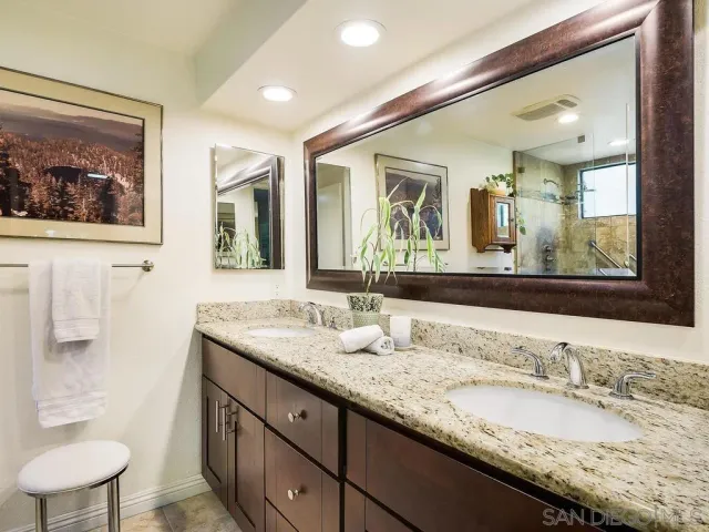 a bathroom with a granite countertop sink mirror and toilet