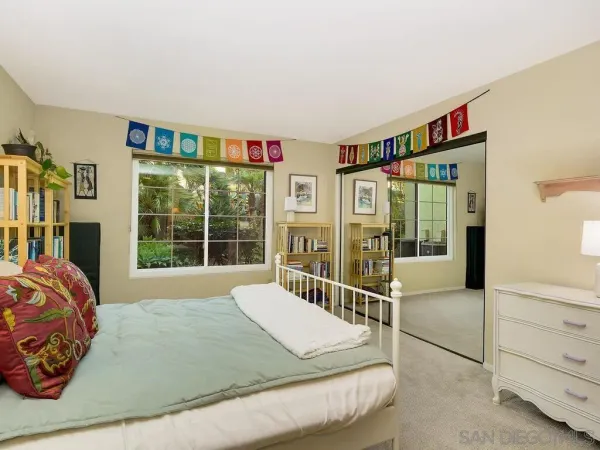 a bed sitting in a bedroom next to a window