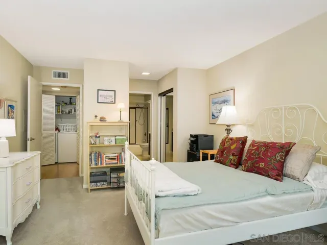 a spacious bedroom with a bed and a cabinets