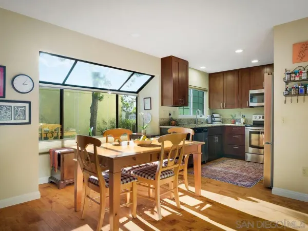 a view of a dining room with furniture a kitchen and chandelier