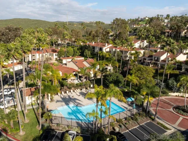 an aerial view of residential houses with outdoor space and trees