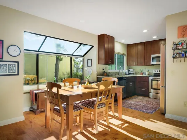 a view of a dining room with furniture a kitchen and chandelier