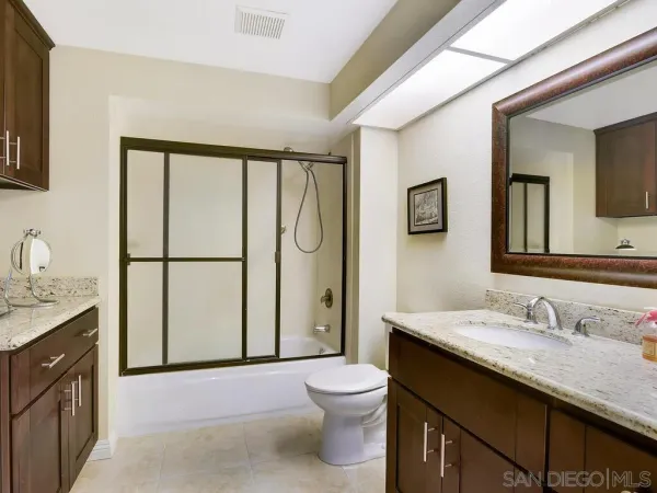 a bathroom with a granite countertop sink toilet and shower
