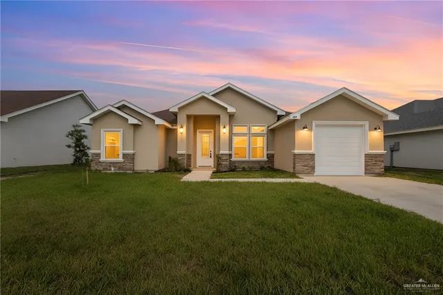 a front view of a house with a garden and yard