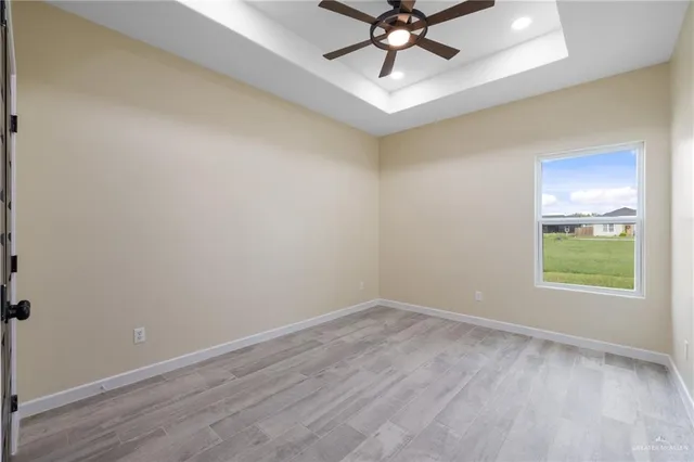 an empty room with a window and a fan