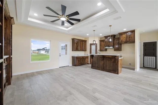 a view of kitchen with microwave refrigerator and cabinets