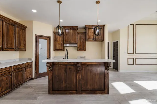 a kitchen with stainless steel appliances granite countertop a refrigerator a sink and a stove